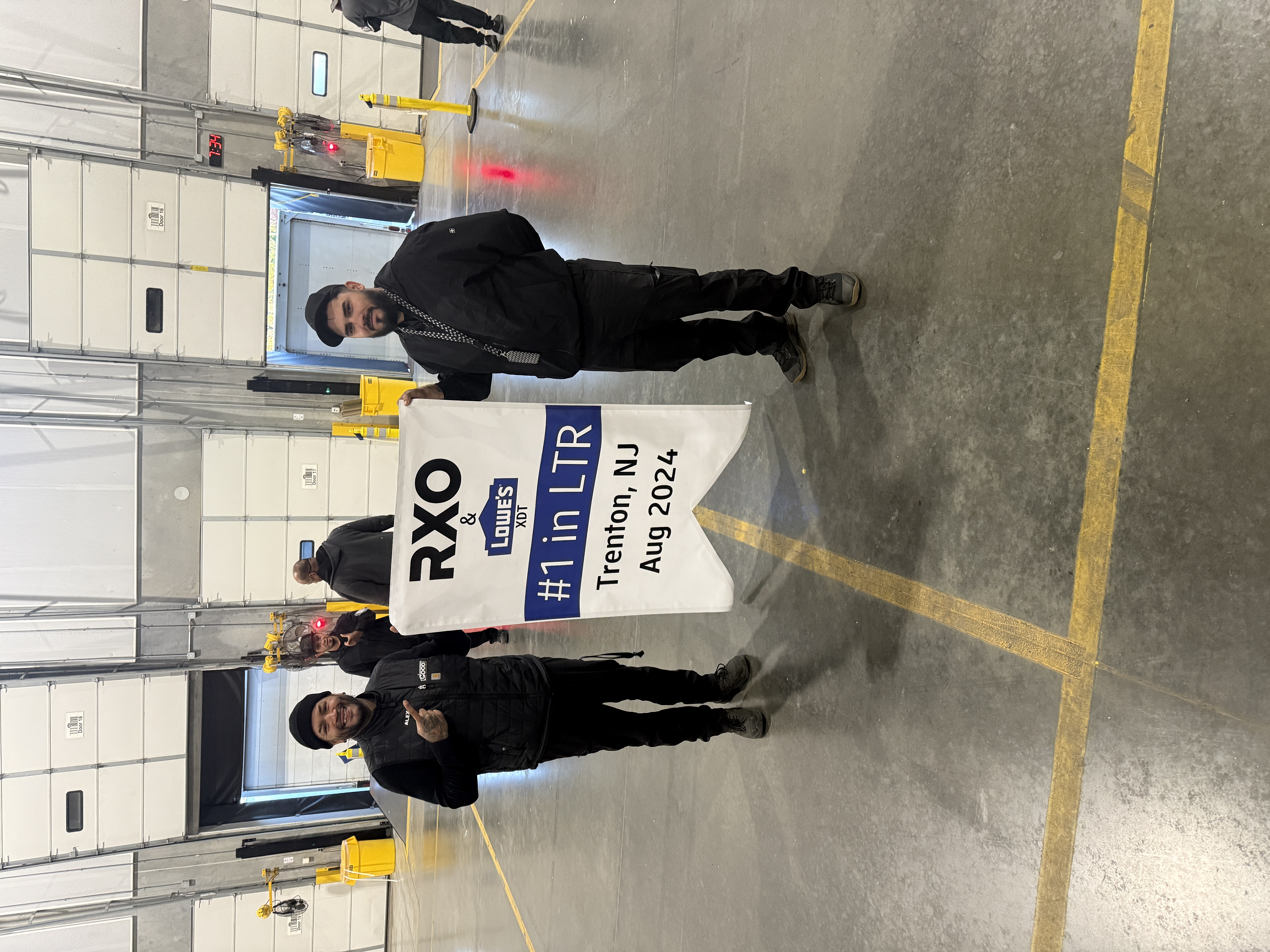 Two team members holding an RXO and Lowe’s XDT banner reading number one in LTR, Trenton, New Jersey, August 2024